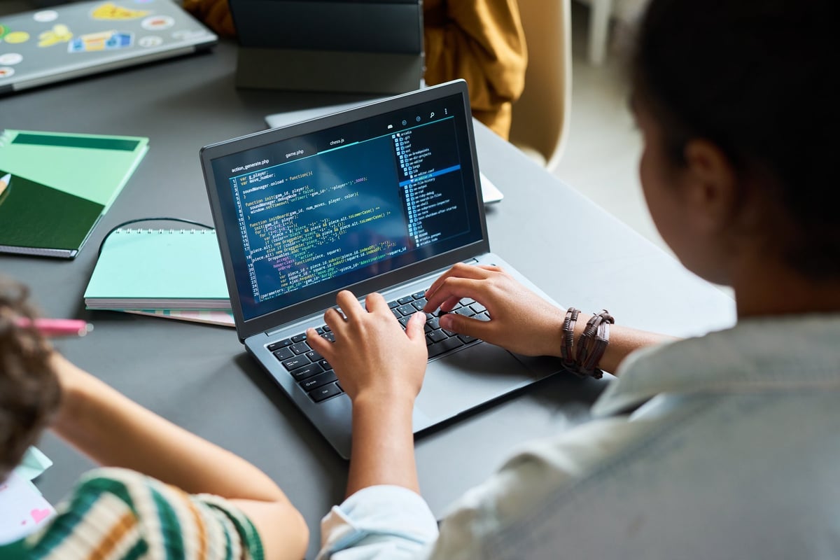 A teenage student coding on a laptop during a technology learning session