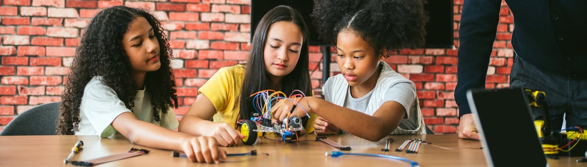 Children collaborating on a robotics project, wiring components and a microcontroller in a hands-on STEM workshop